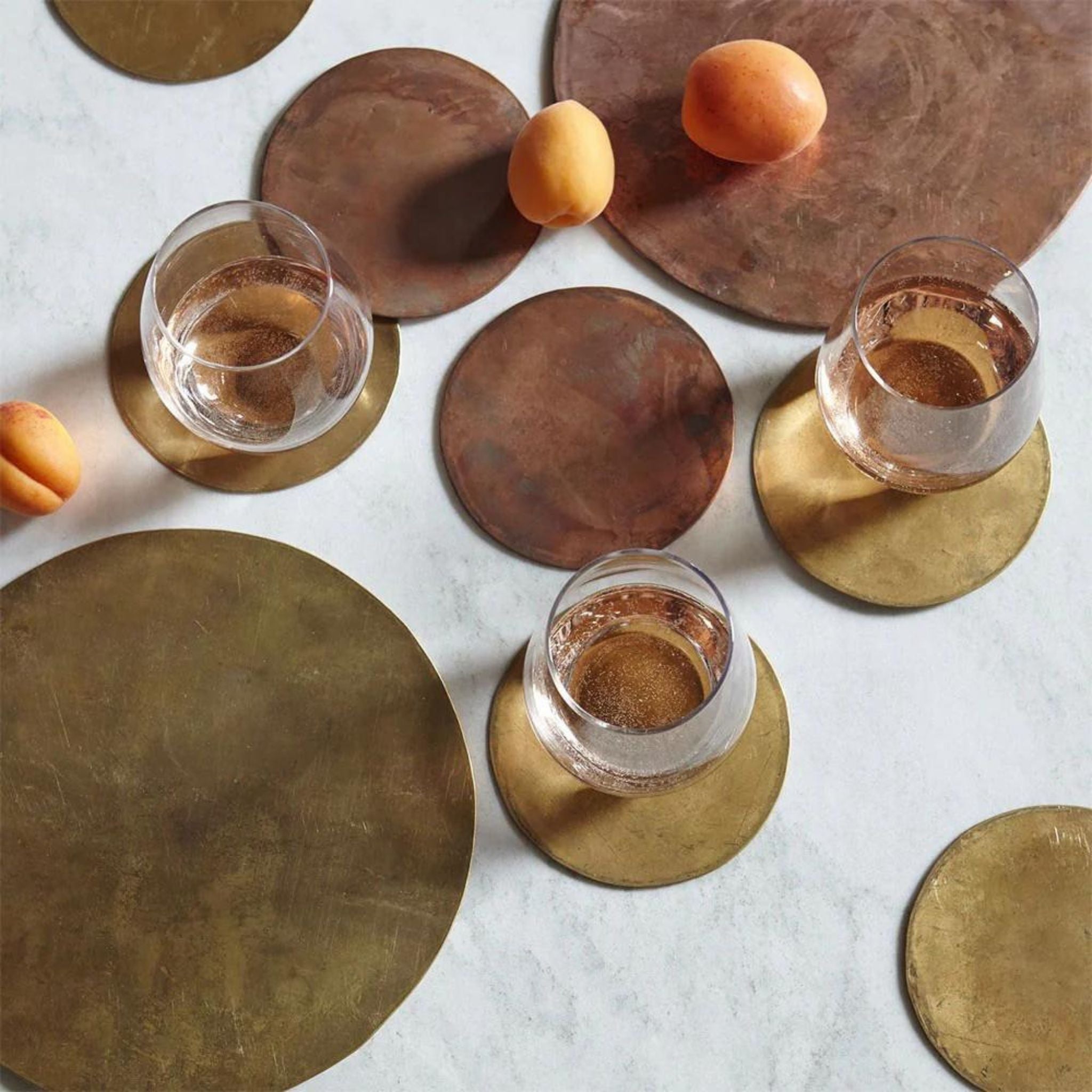 Simply Elevated - These coasters are fashioned using pure metals and alloys that will oxidize over time. They are sold in sets of four, and the graphically patinated disks will age gracefully as their lacquer fades to reveal the natural wear of their use. Available in solid brass, copper-plated brass, or nickel-plated brass, each piece is backed with natural cork to protect your delicate surfaces.