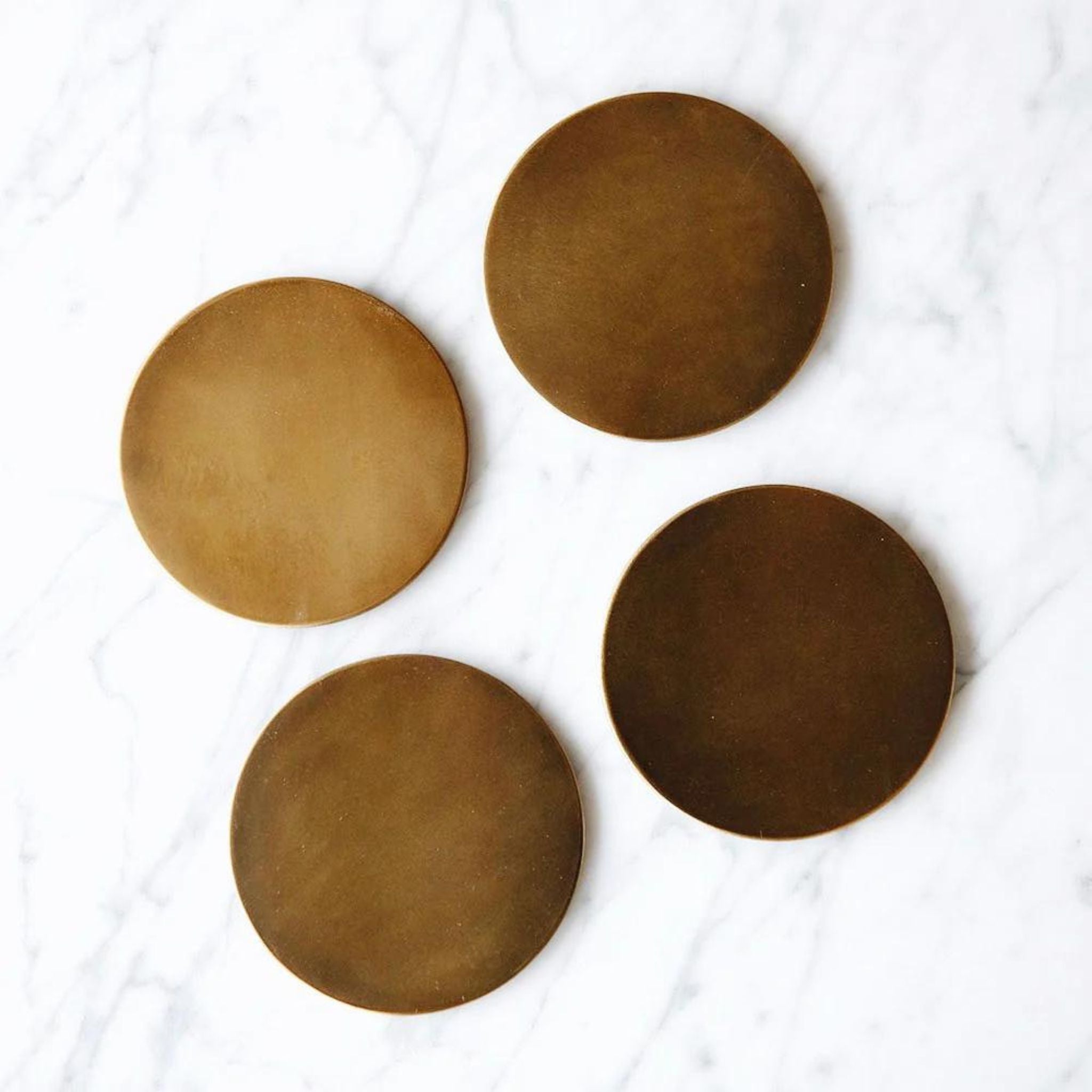 Simply Elevated - These coasters are fashioned using pure metals and alloys that will oxidize over time. They are sold in sets of four, and the graphically patinated disks will age gracefully as their lacquer fades to reveal the natural wear of their use. Available in solid brass, copper-plated brass, or nickel-plated brass, each piece is backed with natural cork to protect your delicate surfaces.